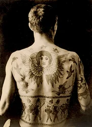 Retrato de un hombre con un elaborado tatuaje en la espalda, c.1910